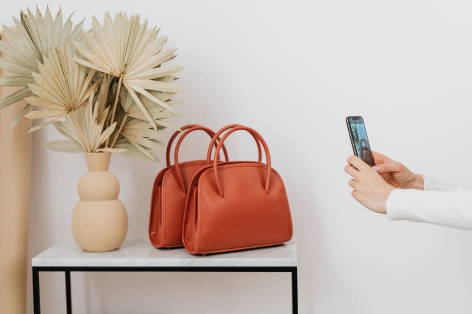 A person photographing products with a phone in bright daylight