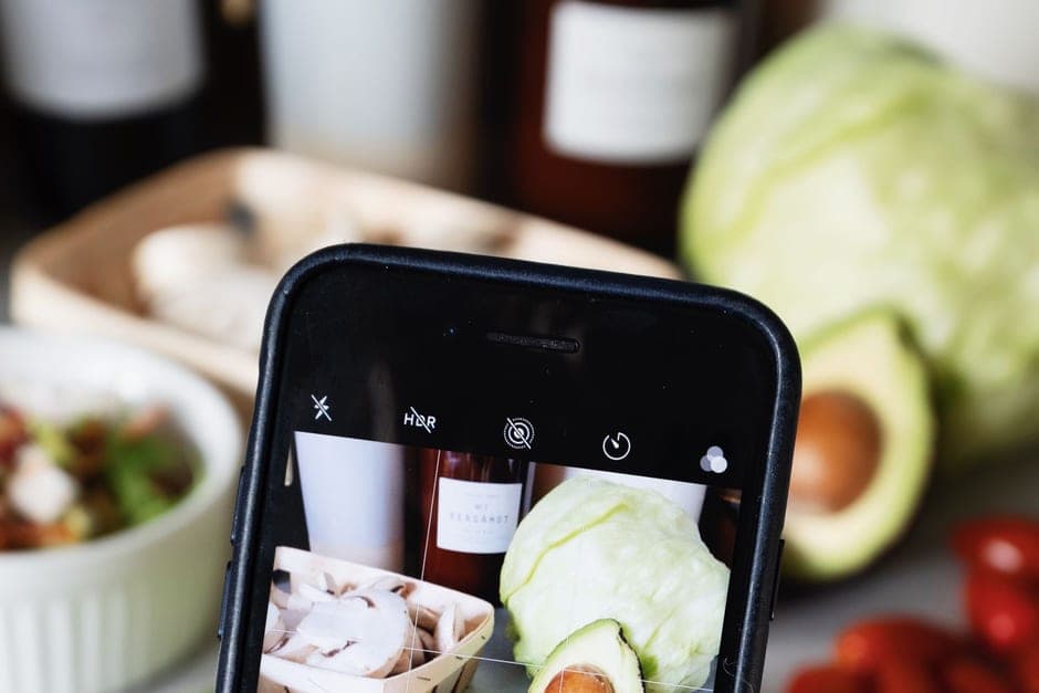 A phone framing a photo of fresh produce on a work surface