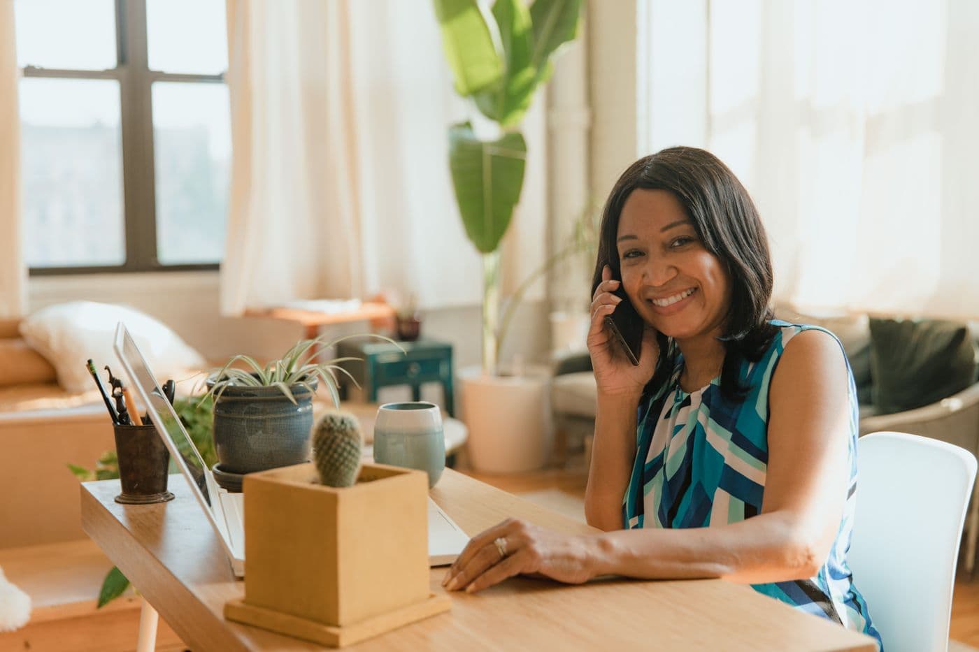 Business owner smiling while a website chat widget captures a new lead from her site 24/7