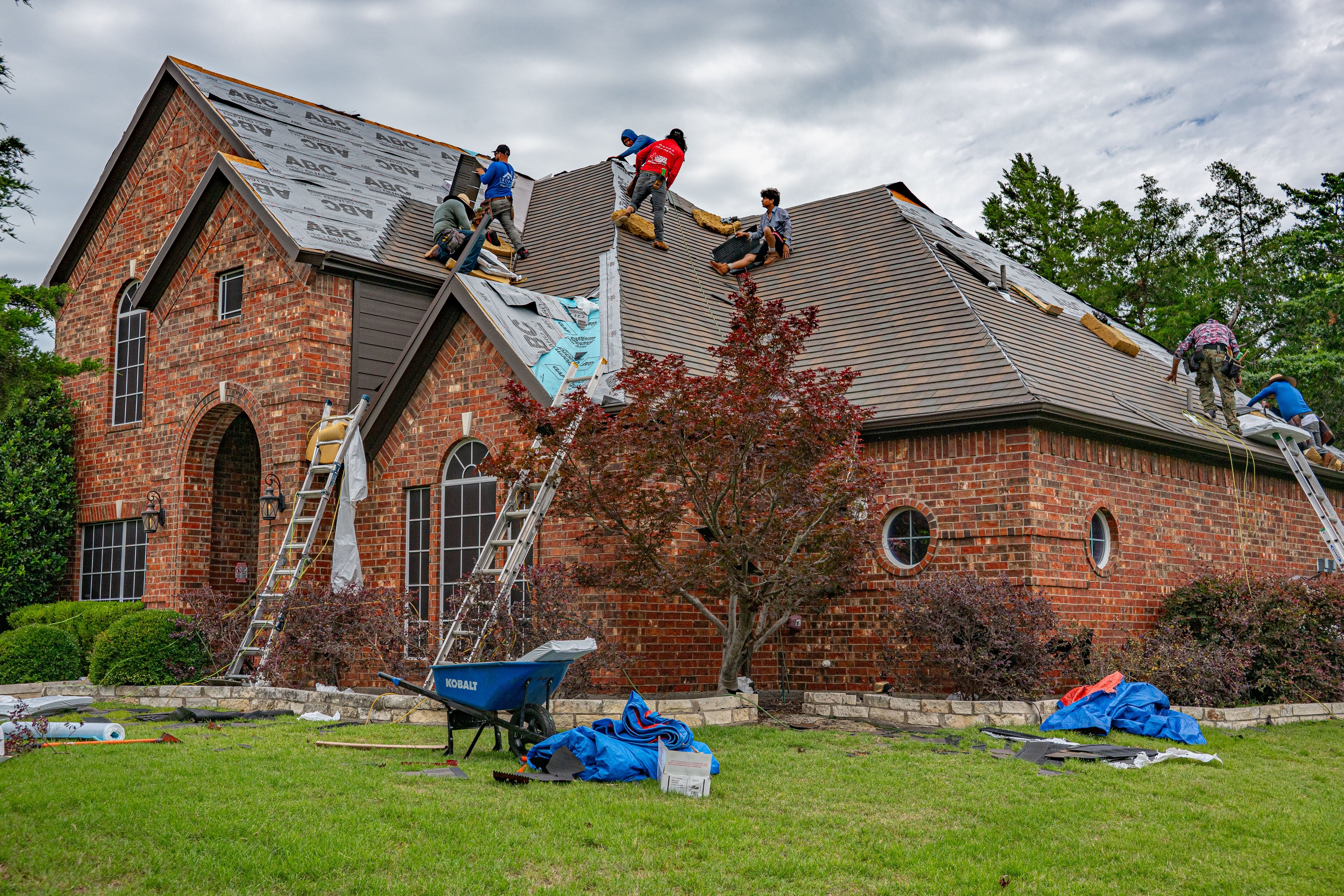Professional roofing crew renovating the roof of a brick home